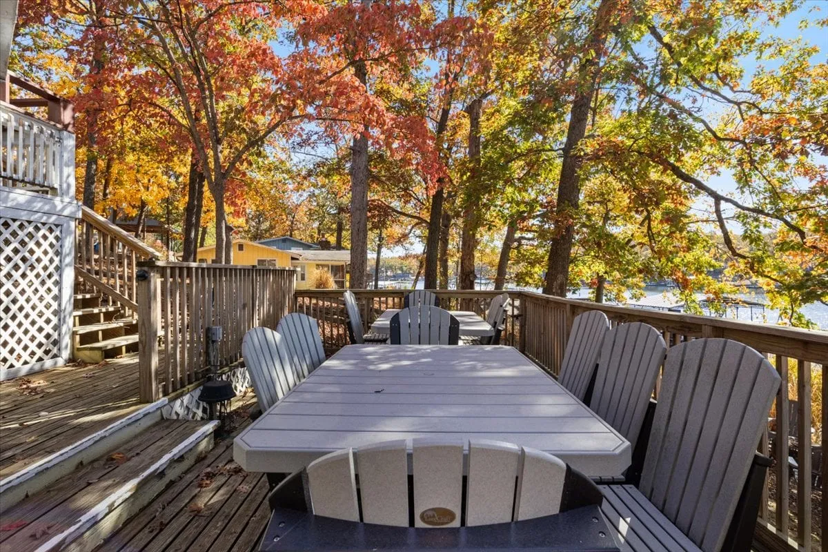 An inviting outdoor dining area with a table set on a deck, surrounded by trees and nature, ideal for alfresco family meals or evening gatherings under the stars.