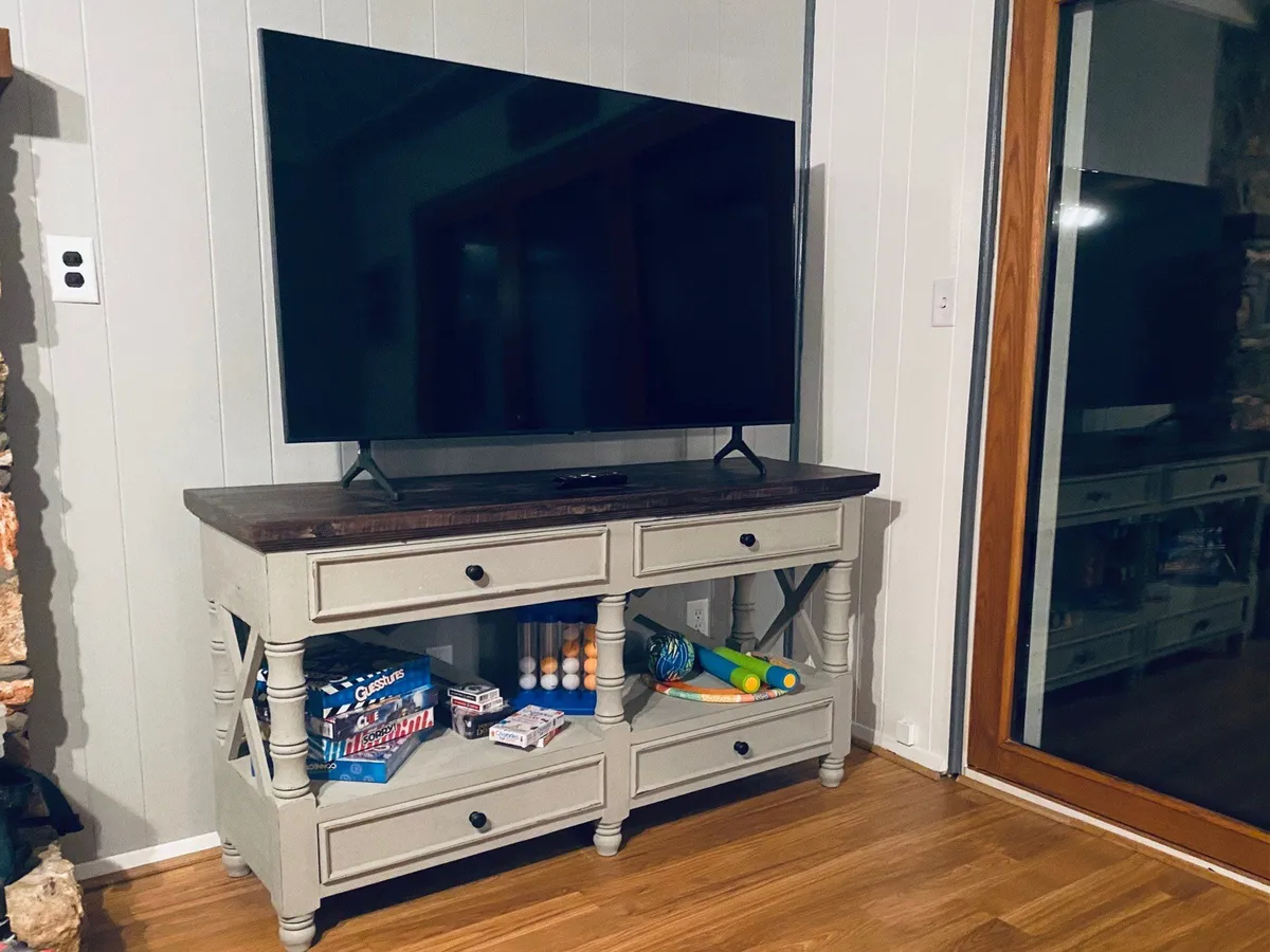 A cozy living area centered around an entertainment console and TV, with a sofa set and playful, colorful accents. The space is perfect for socializing, movie nights, or relaxing after a day of adventure.